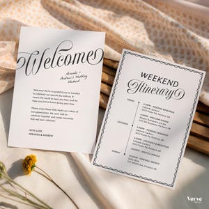 May include: Two white wedding stationery cards with black text. One card says "Welcome" in elegant script, with the names "Miranda + Andrew's Wedding Weekend" below. The other card is a weekend itinerary.