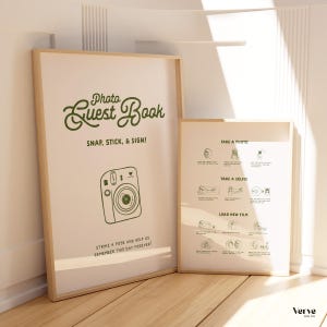 May include: Two framed prints with light wood frames. The larger print reads "Photo Guest Book" with instructions and a camera illustration. The smaller print has photo-taking instructions. Both are leaning against a white wall.