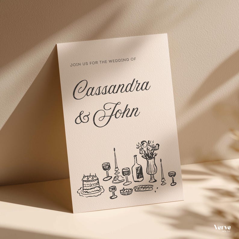 May include: A cream-colored wedding invitation with the text "Join us for the wedding of Cassandra & John." Below the text is a black line drawing of a cake, wine glasses, and a bottle.
