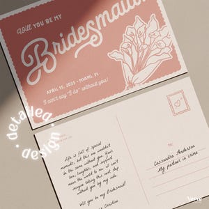 May include: Two pink and white postcards. The top postcard reads "Will you be my Bridesmaid" in cursive script. The bottom postcard has handwritten text and a stamp with a heart. The postcards are for a wedding.