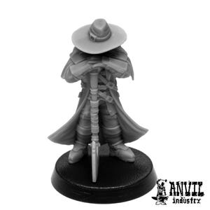 May include: A grey miniature figure of a character wearing a hat and long coat, holding a staff. The figure is mounted on a black circular base. The Anvil Industry logo is visible on the base.