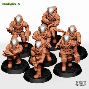 May include: A set of seven unpainted miniature figures in terracotta-colored resin, each wearing a bulky space suit with a smooth, reflective silver-toned helmet visor. The figures are posed in various stances on round black textured bases.