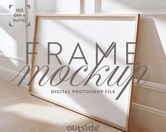 May include: A digital mockup of a wooden frame with a white background. The frame is on a wooden floor with a white wall in the background. The text "FRAME mockup" is written in gray on the frame. The text "DIGITAL PHOTOSHOP FILE" is written in gray below the frame. The text "outside the mock" is written in gray at the bottom of the image.
