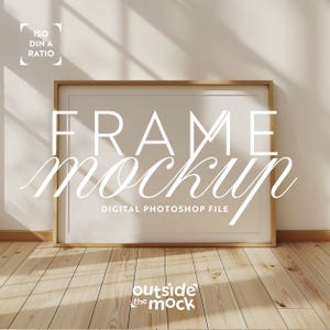 May include: A rectangular frame mockup with a light wood finish, leaning against a neutral-colored wall. The text "FRAME mockup" is displayed in white, along with "DIGITAL PHOTOSHOP FILE". The frame rests on a light wood floor.