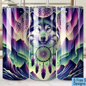 Op de afbeelding: Drie roestvrijstalen bekers met een ontwerp van een wolfskop, een droomvanger en een kleurrijk noorderlicht. De wolfskop bevindt zich in het midden van de beker, met de droomvanger en het noorderlicht aan beide kanten.
