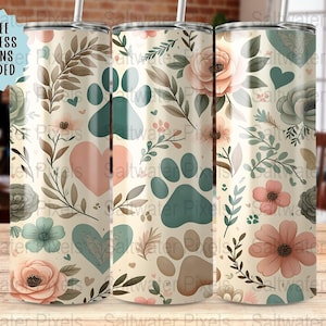 May include: Three beige tumblers with floral and paw print designs. The tumblers feature pink and teal flowers, hearts, and paw prints, with the text "6 FREE SEAMLESS DESIGNS INCLUDED" in a blue circle.