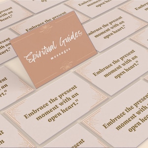 May include: A set of beige cards with gold accents and a decorative design. Each card features the text "Embrace the present moment with an open heart." The cards are part of a set called "Spiritual Guides Messages".