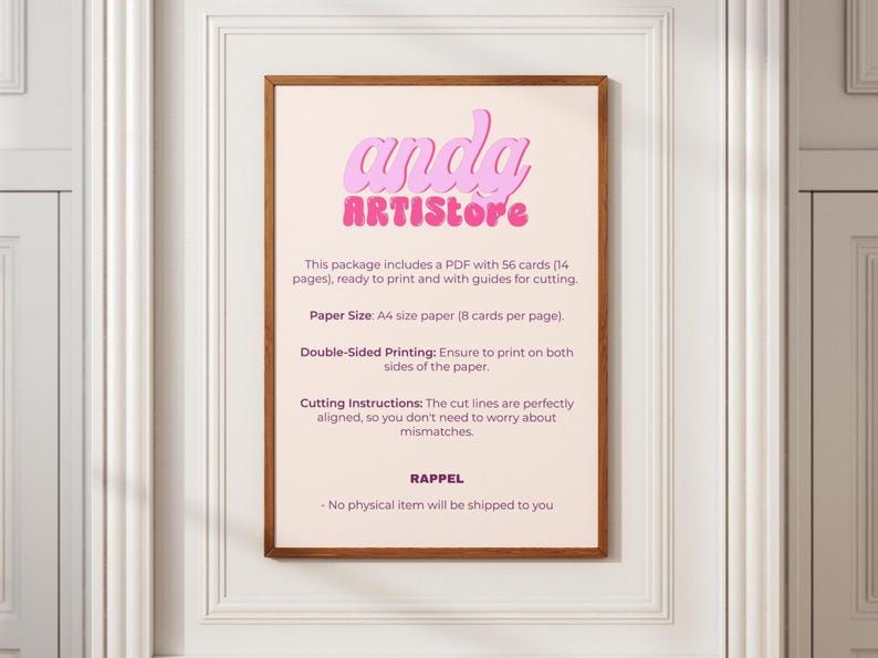 May include: A framed print with the text "anda ARTISTore" in pink and purple. The print provides instructions for printing cards, including paper size, double-sided printing, and cutting instructions. The frame is brown, and the background is a light beige.