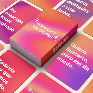 Pode incluir: Um baralho de 80 cartas com o texto "MENSAJES NO DICHOS" na caixa. As cartas e a caixa têm um gradiente de rosa, laranja e roxo. Cartas individuais exibem frases em espanhol.