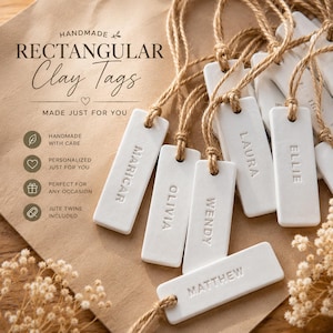 May include: A collection of rectangular white clay tags, each featuring an embossed name including Maricar, Olivia, Wendy, Laura, Ellie, and Matthew. Each tag is attached to a natural jute twine string. The text on the image reads HANDMADE RECTANGULAR Clay Tags MADE JUST FOR YOU.