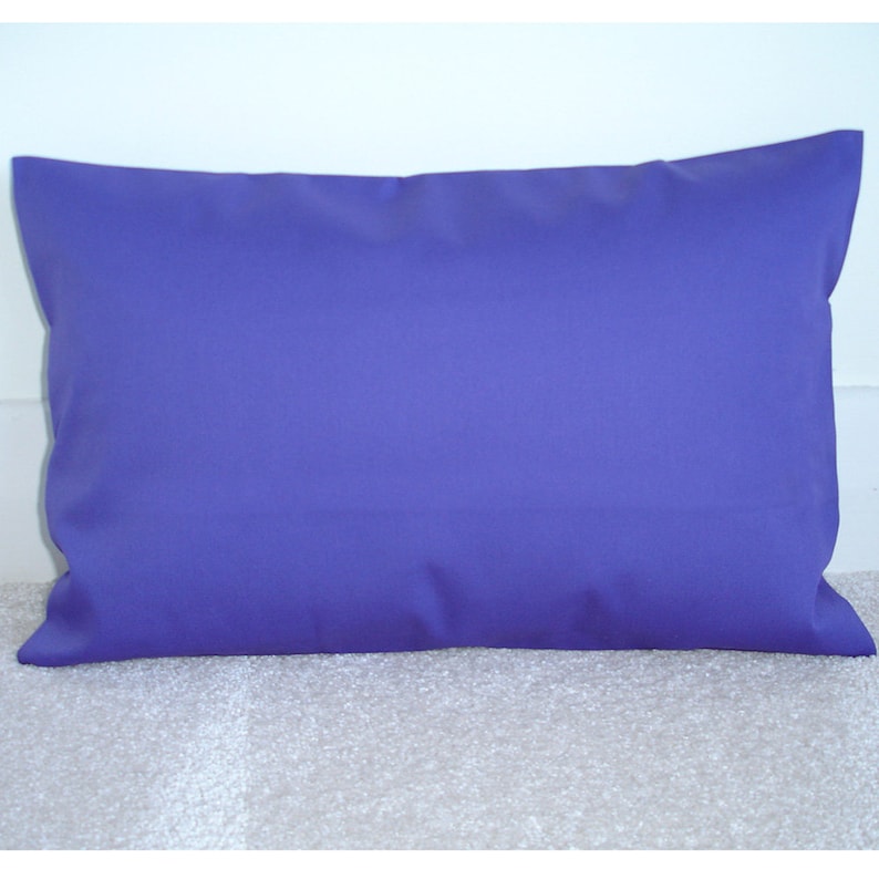 May include: A solid purple pillow with a rectangular shape. The pillow is made of a soft, smooth fabric.