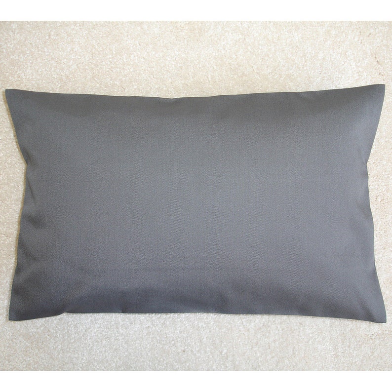 Może przedstawiać: Prosta szara poduszka z gładką, jednolitą powierzchnią tkaniny.