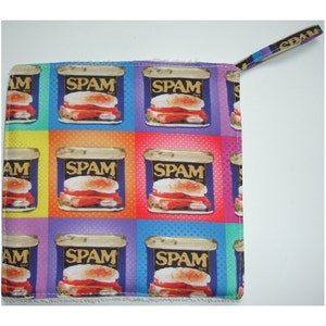May include: A colourful kitchen pot holder with a repeating pattern of Spam luncheon meat cans. The cans are blue with white and red lettering and feature a Spam sandwich.
