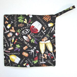 May include: Black and white pot holder with a variety of wine-themed illustrations, including wine glasses, corkscrews, grapes, and wine bottle labels. The text on the pot holder includes the names of different types of wine, such as Chardonnay, Merlot, Pinot Noir, and Sauvignon Blanc.