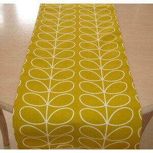 May include: A yellow table runner with a white stylised leaf pattern.