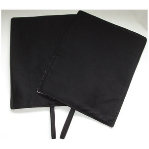 May include: Two black fabric squares with straps, possibly for a photography backdrop.