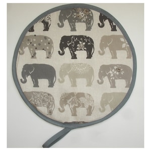 May include: Round grey and white pot holder with a grey trim and a grey handle. The pot holder is decorated with a pattern of grey elephants on a white background.