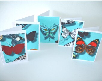 May include: Set of six blank greeting cards with a turquoise background and colorful butterfly illustrations. Each card features a different butterfly design.