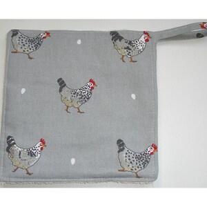 May include: Grey kitchen towel with a white polka dot pattern and a black and white chicken design. The towel has a loop handle.
