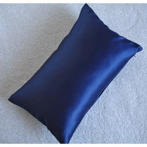 May include: A dark blue satin pillowcase. The pillowcase is smooth and has a zipper closure.