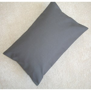 Może przedstawiać: Prosta, szara, prostokątna poduszka z gładką powierzchnią tkaniny.