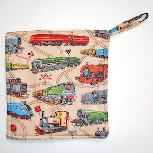 May include: A beige cotton pot holder with a colorful print of various trains and train tracks. The pot holder has a loop handle.