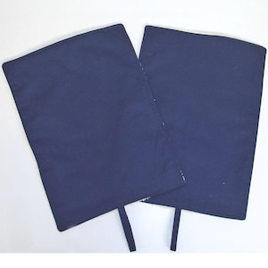 May include: Two dark blue fabric knee pads with straps. The knee pads are rectangular and have a smooth surface.