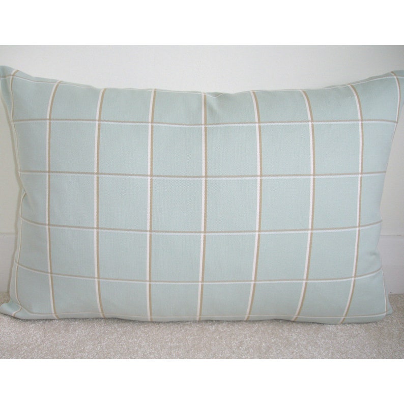 May include: A light blue throw pillow with a tan and white plaid pattern.