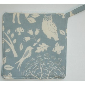 May include: A blue fabric pot holder with a white owl, bird, butterfly, mushroom, and floral design.