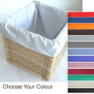 May include: A square woven wicker basket featuring a removable light gray fabric liner. To the right, a vertical color chart displays twelve fabric options including red, blue, orange, brown, light gray, dark gray, light blue, purple, pink, maroon, green, cream, and black. The text "Choose Your Colour" is printed below.