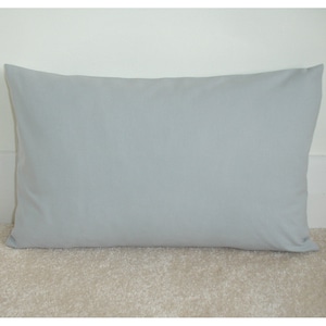 May include: A light grey rectangular cushion with a smooth, even surface.