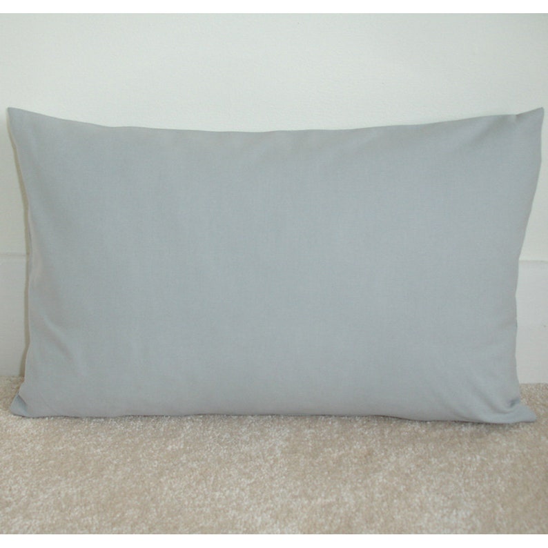 May include: A light grey rectangular cushion with a smooth, even surface.