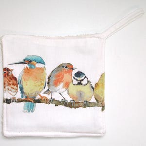 May include: A white cotton pot holder with a colourful illustration of five birds perched on a branch. The birds are a bluebird, a robin, a blue tit, and two other birds.