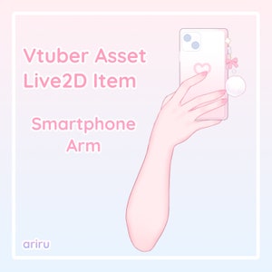 May include: A pink smartphone with a heart and a white fluffy charm attached to the case. The phone is being held by a pink hand with long nails. The text "Vtuber Asset Live2D Item Smartphone Arm" is written in pink letters on a light blue background.