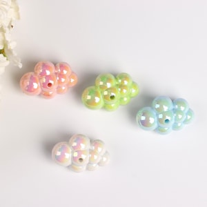 Puede incluir: Cuatro porta inciensos de cerámica iridiscente en forma de nube en rosa, verde, azul y blanco.