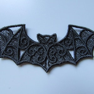 Peut inclure: Applique de chauve-souris en dentelle noire avec des détails complexes. Ce motif délicat est parfait pour ajouter une touche de charme d'Halloween à l'artisanat et aux projets.