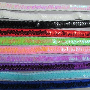 May include: Assortment of sequin trim ribbon in various colors, including white, black, red, green, pink, purple, blue, and navy. The trim is approximately 1 inch wide and features a row of sequins.