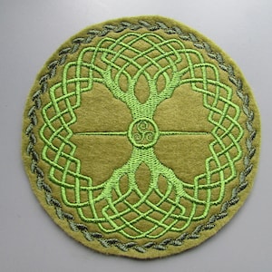 May include: A green and brown felt circle with an embroidered Celtic knot design. The knot design is a tree of life with a triskelion at the center.