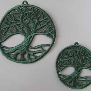 May include: Two green embroidered tree of life designs. The larger design is about 12.5 cm in diameter and the smaller design is about 7.5 cm in diameter.