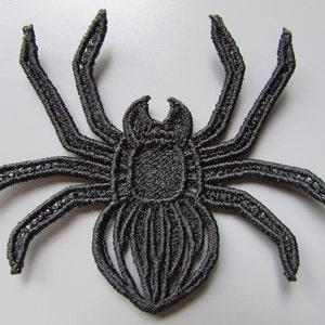 May include: Black embroidered spider applique. This detailed spider is perfect for adding a spooky touch to crafts and projects.