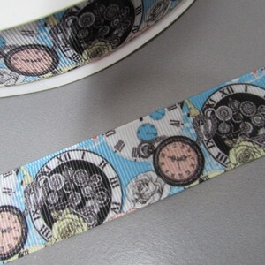 May include: White and blue ribbon with a repeating pattern of pocket watches and roses. The watches have Roman numeral faces and black hands. The roses are white and yellow.