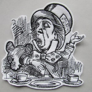 May include: Black and white embroidered patch of the Mad Hatter from Alice in Wonderland. He is wearing a tall hat with the word "Mad Hatter" on it. He is holding a teacup and saucer.