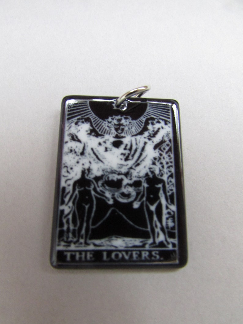 May include: Black and white tarot card pendant featuring the Lovers card image and the text "THE LOVERS."