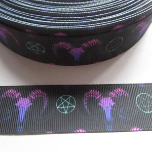 Könnte beinhalten: Schwarzes Satinband mit einem sich wiederholenden Muster aus rosa und violetten Widderköpfen und grünen Pentagrammen.