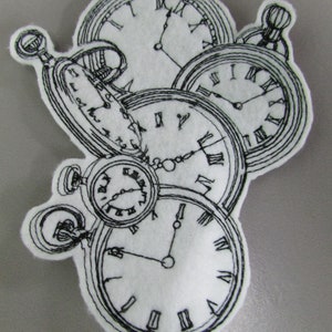 May include: A close-up of a white fabric patch with five embroidered pocket watches. The watches are all different sizes and have Roman numeral markings. The watches are arranged in a cluster, with the largest watch at the top and the smallest watch at the bottom.
