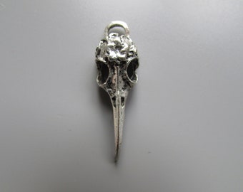 May include: Silver pendant charm in the shape of a bird skull with a detailed design.