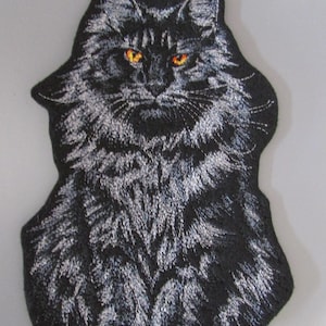 May include: Embroidered patch depicting a black cat with vivid orange eyes. The cat's fur is detailed with white and grey stitching, giving a textured look. The patch is cut to the cat's shape, ideal for attaching to garments or accessories.