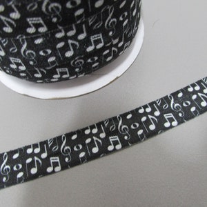 May include: Black and white ribbon with a repeating pattern of musical notes. The ribbon is approximately 1 inch wide.