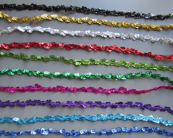May include: Assortment of 10 colors of sequined trim. The trim is made of small, round sequins sewn onto a thin, flexible fabric. The colors are black, gold, silver, red, green, pink, purple, teal, and blue.