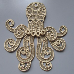 Peut inclure: Applique en dentelle d'octopus de couleur or avec des détails complexes. La pieuvre a huit tentacules enroulés et une tête détaillée.